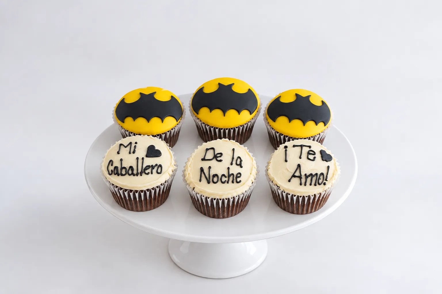 Cupcakes con símbolos de murciélago negros sobre círculos amarillos