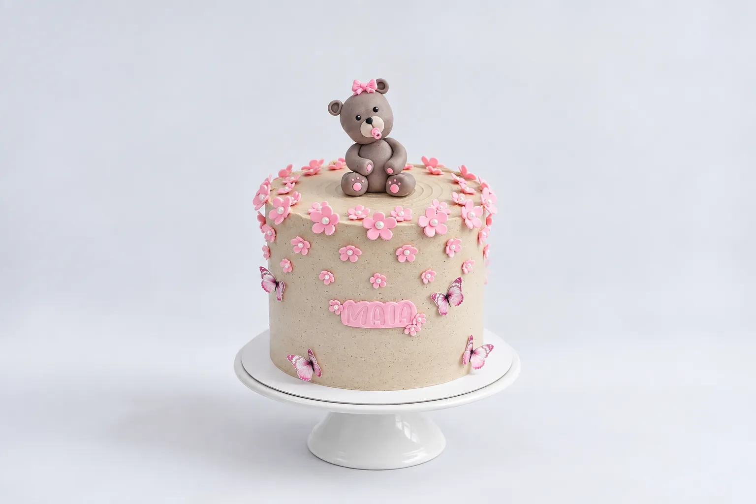 Torta rosa con flores pequeñas y osito gris en la parte superior