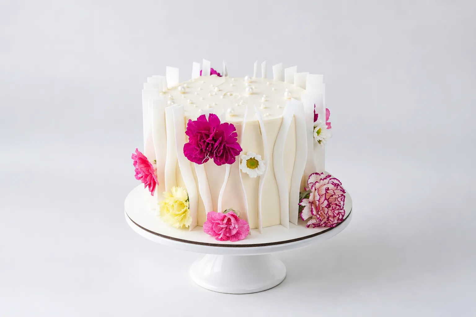 Torta blanca con relieves verticales y flores fucsias, rosas y amarillas